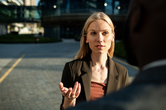 Businesswoman talking with coworker outside office building