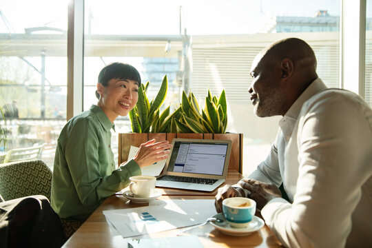 Two business professionals meeting at cafe table
