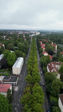 aerial drone video of Koskelantie in the K&auml;pyl&auml; area of Helsinki, Finland, surrounded by lush green trees and urban residential buildings during summertime.