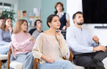 Obraz premium Group of young people attend classes to prepare for exams, they participate in lectures and discussions. Students carefully watch the presentation