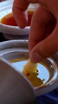 Marrakech, morocco. August 9, 2026. Moroccan appetizer featuring a hand dipping fresh bread into a bowl of argan oil. Traditional amlou dip in the background, close up shot