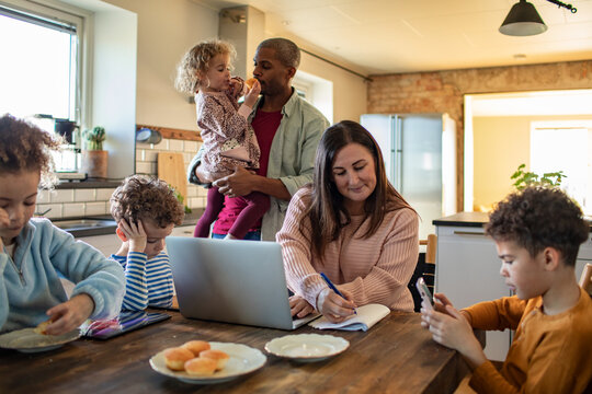 Parents working from home with kids in kitchen