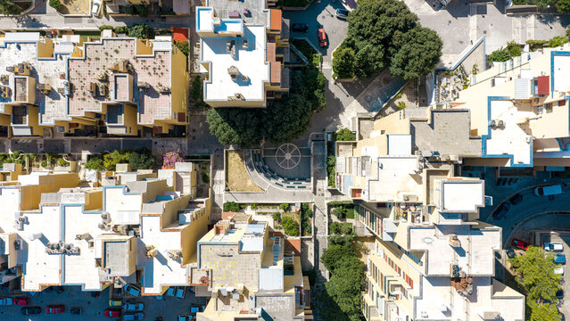Aerial view of residential buildings with flat roofs, a small paved courtyard with a circular design, and surrounding greenery in Split, Split-Dalmatia County, Croatia.