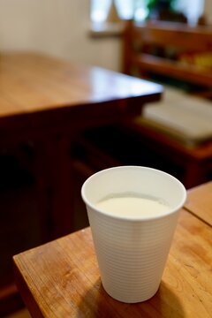 四国カルスト産牛乳。白いカップに入った新鮮な牛乳。コピースペースあり