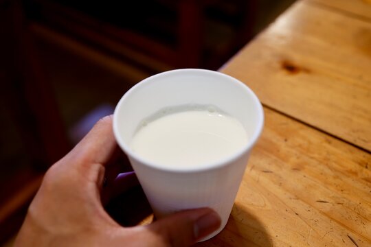 四国カルスト産牛乳。白いカップに入った新鮮な牛乳。コピースペースあり