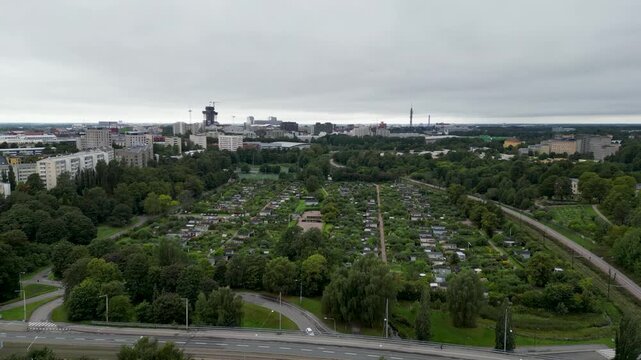 l aerial drone video of Kumpula Botanical Garden in Helsinki, Finland, showing lush green gardens, trees, plants, and peaceful summer scenery surrounded by the city.