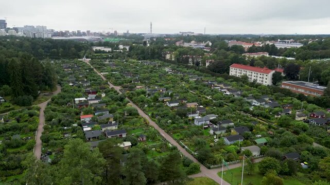 aerial drone video of Kumpula Botanical Garden in Helsinki, Finland, featuring lush green vegetation, gardens, trees, and peaceful summer scenery in the heart of the city.