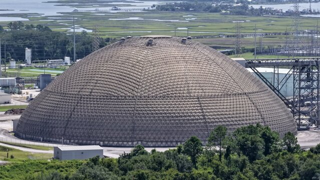 Aerial view of the JEA Northside Generating Station coal storage dome, a large geodesic structure surrounded by industrial infrastructure and wetlands, Jacksonville, Florida, United States.