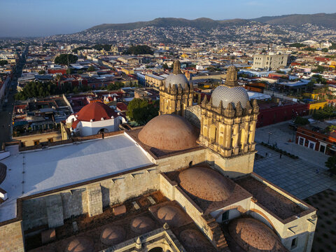 Aerial view of the Church of Santo Domingo de Guzman with its iconic domes and colonial architecture overlooking the city skyline of Oaxaca, Oaxaca, Mexico.