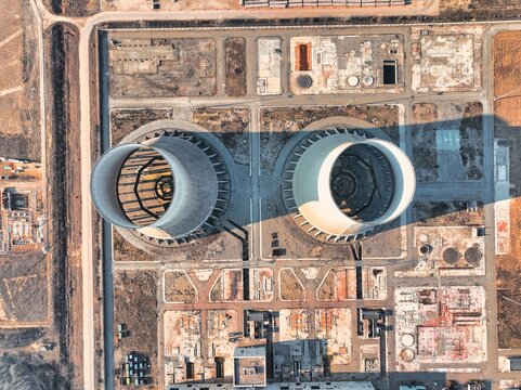 Aerial view of the decommissioned Trino Vercellese Power Plant featuring two large hyperbolic cooling towers surrounded by industrial structures in Trino, Piedmont, Italy.