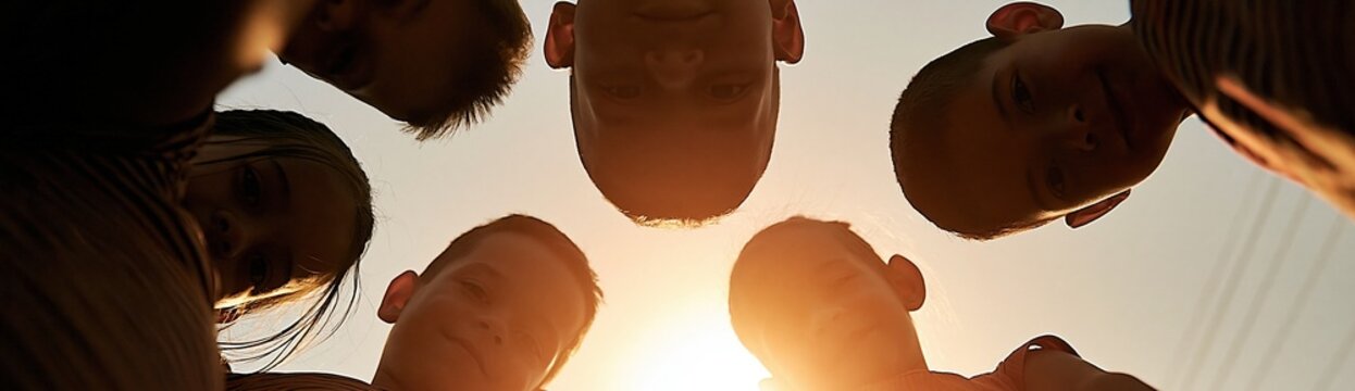Diverse group of children forming a circle of unity and friendship against a bright, warm sunset sky
