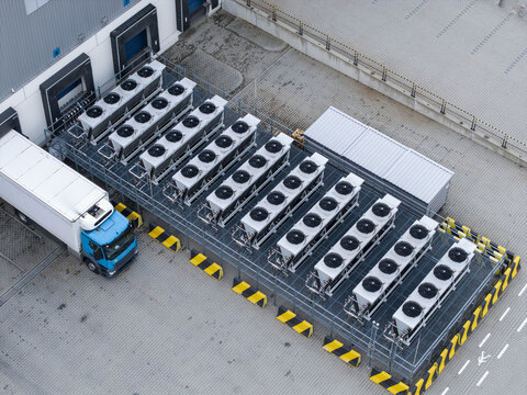 Aerial view of an industrial ai data center cooling system with rows of large fans on a metal platform next to a parked truck in an industrial yard in Krakow, Lesser Poland Voivode, Poland.