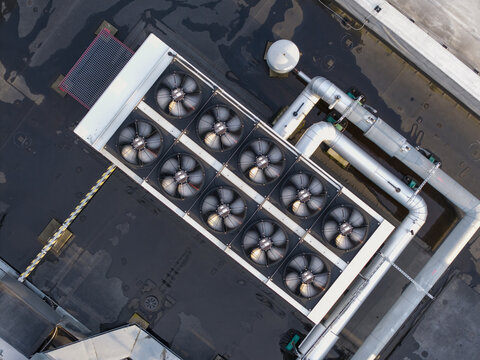 Aerial view of an industrial cooling system with large fans and metal piping installed on a rooftop in Krakow, Lesser Poland Voivode, Poland.