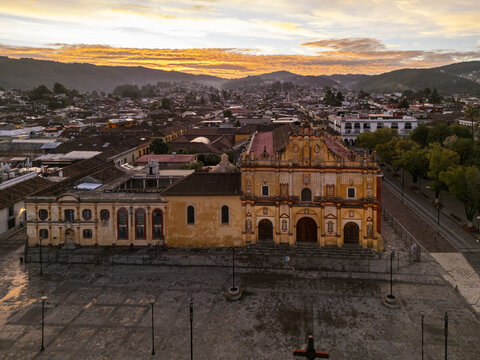 Aerial view of the Cathedral of San Cristobal de las Casas at sunrise, featuring colonial architecture, red-tiled rooftops, and the town square in San Cristobal de las Casas, Chiapas, Mexico.