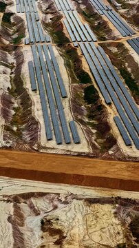 Rows of solar panels cover terraced excavated ground at Hambach open pit mine, aerial