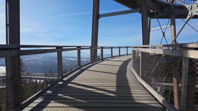 SkyWalk Serce Poronina observation deck near Male Ciche, Poland, with snowy Tatra mountain views, forested slopes, and elevated wooden and steel walkways on a sunny winter day.