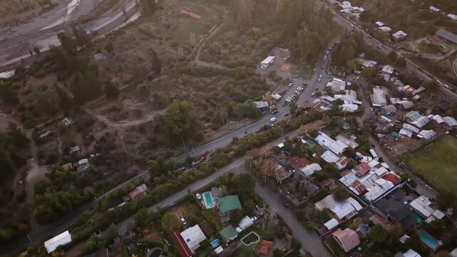aerial, view, drone, footage, mountain, town, residential, houses, rooftops, pools, backyard, road, cars, vehicles, traffic, trees, green, river, winding, water, dense, settlement, neighborhood, remot