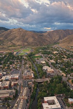 Aerial view of the town of Golden, featuring the historic downtown, Clear Creek, and the iconic M on the mountain under a cloudy sky in Golden, Colorado, United States.