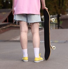 Woman with skateboard in skate park, closeup © New Africa