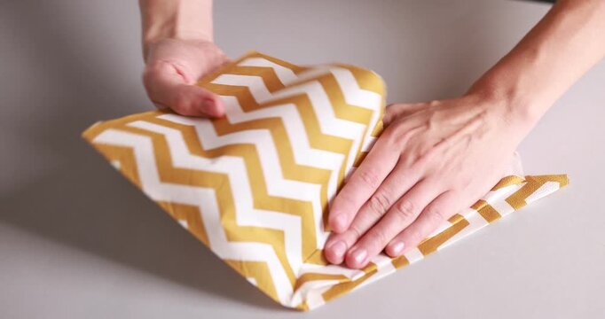 Man folding napkin at white table indoors, closeup