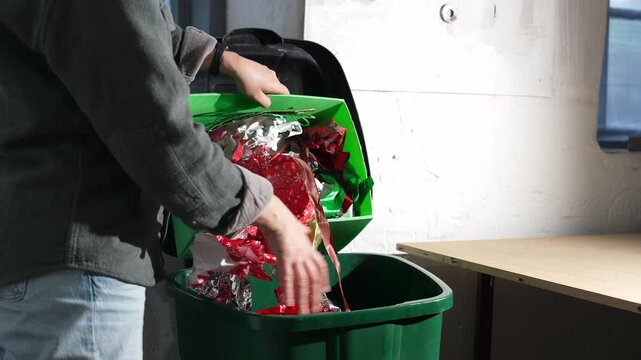 Holiday waste problem. Woman throwing away Christmas gift wrapping and decorations waste
