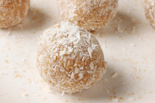 Brazilian coconut beijinho on a rustic plate, coated with shredded coconut. A traditional confectionery treat for parties and celebrations.