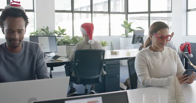 Christmas cheer inspiring African-American man typing laptop at desk pal scrolling phone