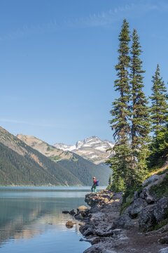 Hiker at Garibaldi Lake, turquoise mountain lake, reflection of a mountain range, Guard Mountain and Deception Peak, glacier, Garibaldi Provincial Park, British Columbia, Canada