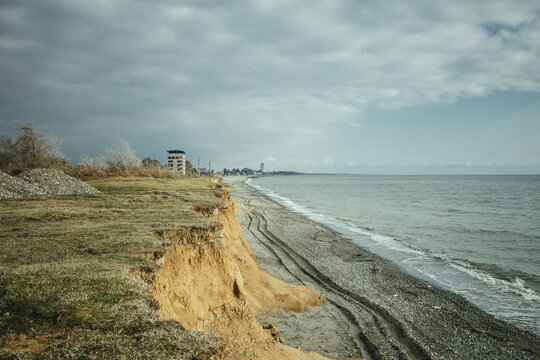 Beach and view of the city. The higher building is the 16-florr-building, as locals call it. Investors wanted to build a hotel there, but when the war broke out, the project was abandoned, Ochamchira, Abkhazia, Georgia
