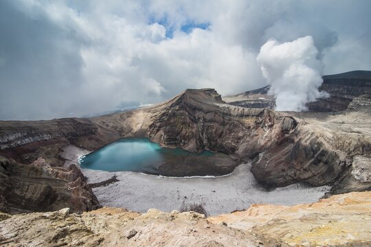 Steaming fumarole with crater lake on the Gorely volcano, Kamchatka, Russia