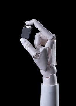 Robotic Hand Holding SD Memory Card Isolated on Black Background