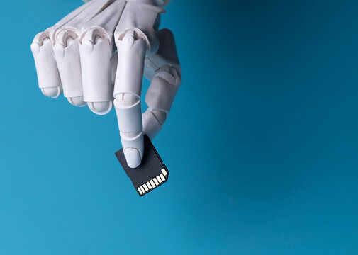Robotic Hand Holding SD Memory Card Concept of AI Data Storage Close Up