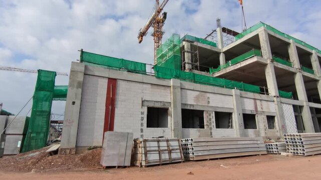 A large multi-storey high-rise building is under construction. The massive structure showcases active urban development and modern engineering.
