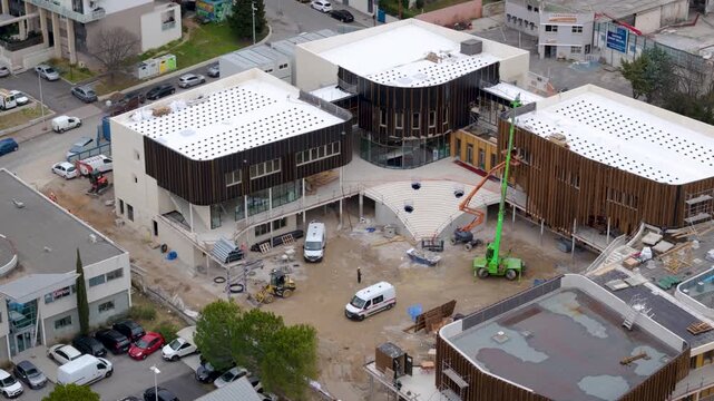 Modern building complex under construction with cranes and equipment in Montpellier, aerial