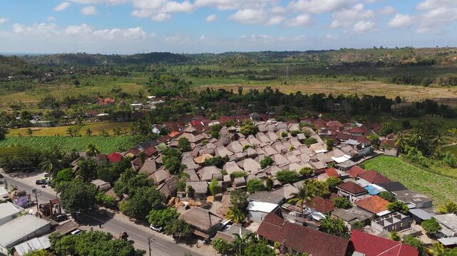 Sade Village and its traditional Sasak houses spread across rural Lombok in a smooth right-orbit drone shot.