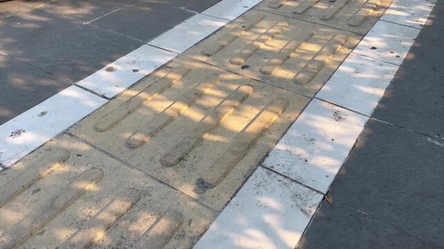 Yellow Tactile Paving Blocks for Blind People on Concrete Sidewalk