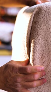 A sequence that first shows the surface of the light, fluffy, and embossed fabric; then reveals the edge and the stitching that hands adjust and check with precision