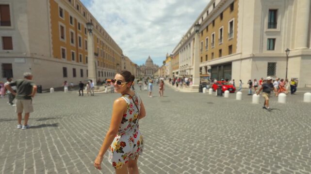 Young Tourist Woman Walking Toward St. Peter&rsquo;s Basilica On Rome Cobblestone Street In Summer in Italy