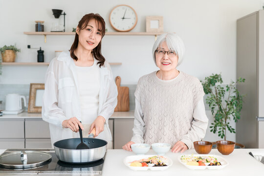 キッチンで一緒に料理を楽しむ母と娘の笑顔