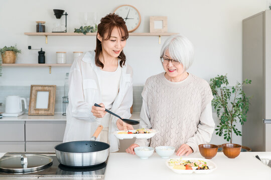 キッチンで仲良く料理を楽しむ義母と嫁