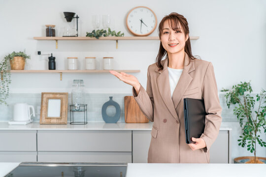 住宅展示場,モデルルームで住まいの提案をする数宅メーカーの女性営業スタッフ