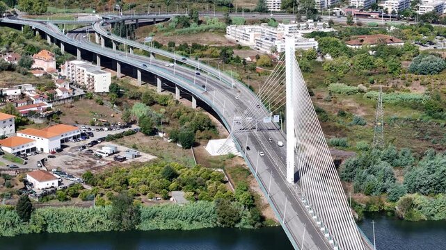Aerial view of the cable-stayed Ponte Rainha Santa Isabel crossing the Mondego River with surrounding urban infrastructure in Coimbra, Coimbra, Portugal.