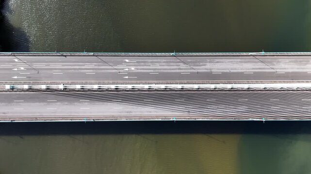 Aerial view of Ponte Rainha Santa Isabel bridge spanning the river with a single car driving across the asphalt surface in Coimbra, Coimbra, Portugal.