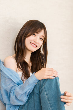 A young Asian woman in casual fashion, wearing a blue shirt in a relaxed style.
