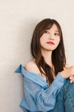A young Asian woman in casual fashion, wearing a blue shirt in a relaxed style.