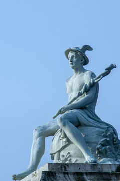 Statue of Mercury, the Roman god and messenger of the gods, against blue sky.