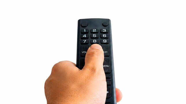Close up of hand pressing button on black TV remote control isolated on white background. Remote control action, home entertainment concept, everyday technology gesture, and controller photo.
