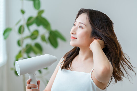 ドライヤーで髪を乾かす40代女性,ヘアケアと美髪習慣