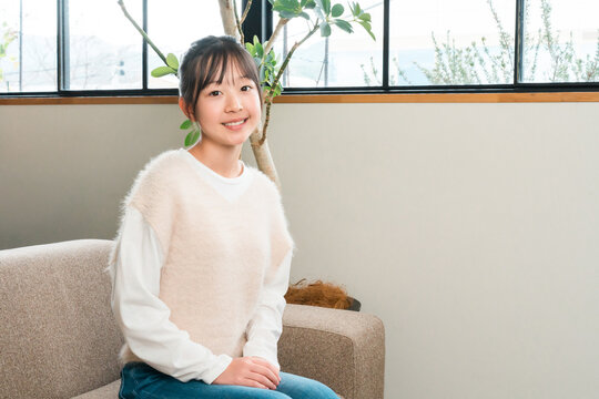 A smiling girl sitting on the sofa in her home.