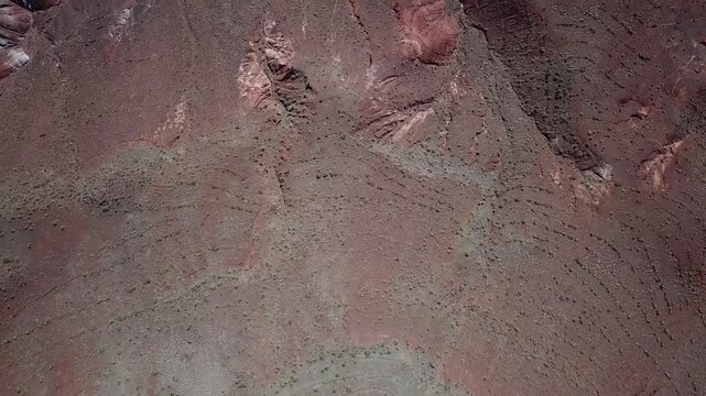 Aerial view of rugged terrain of the Atlas Mountains with arid slopes and geological textures in Morocco.